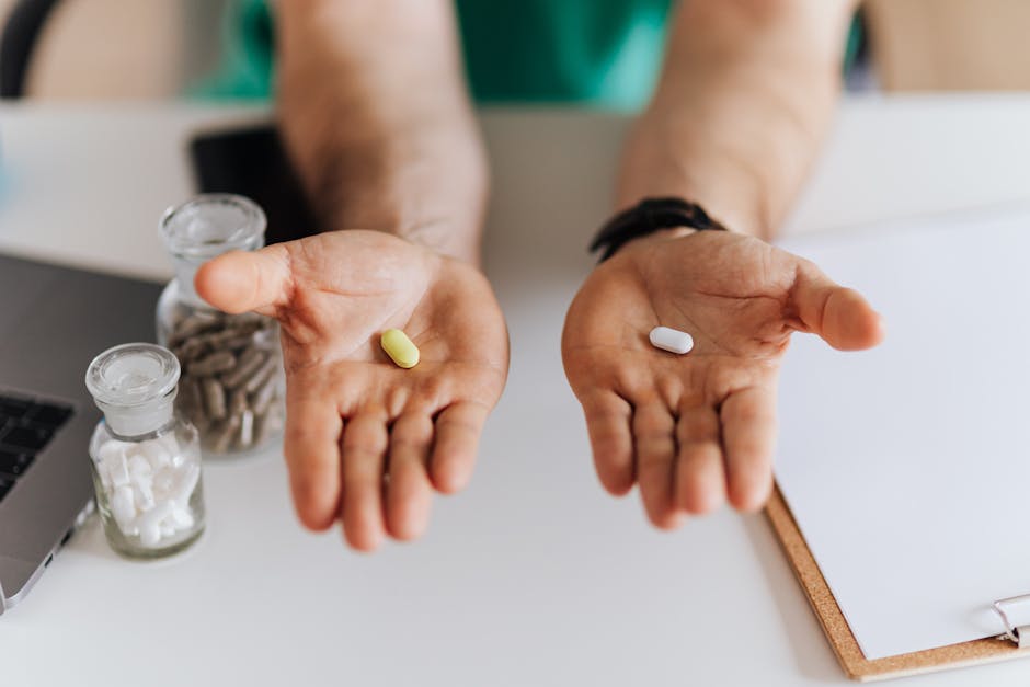 Unrecognizable male doctor sitting at table and demonstrating medicine to patient while working in modern clinic and talking with client about healthy
