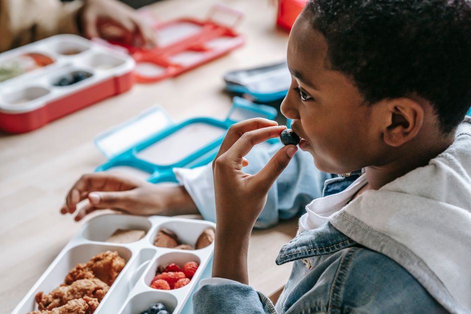 Child eating from a lunchbox with compartments
