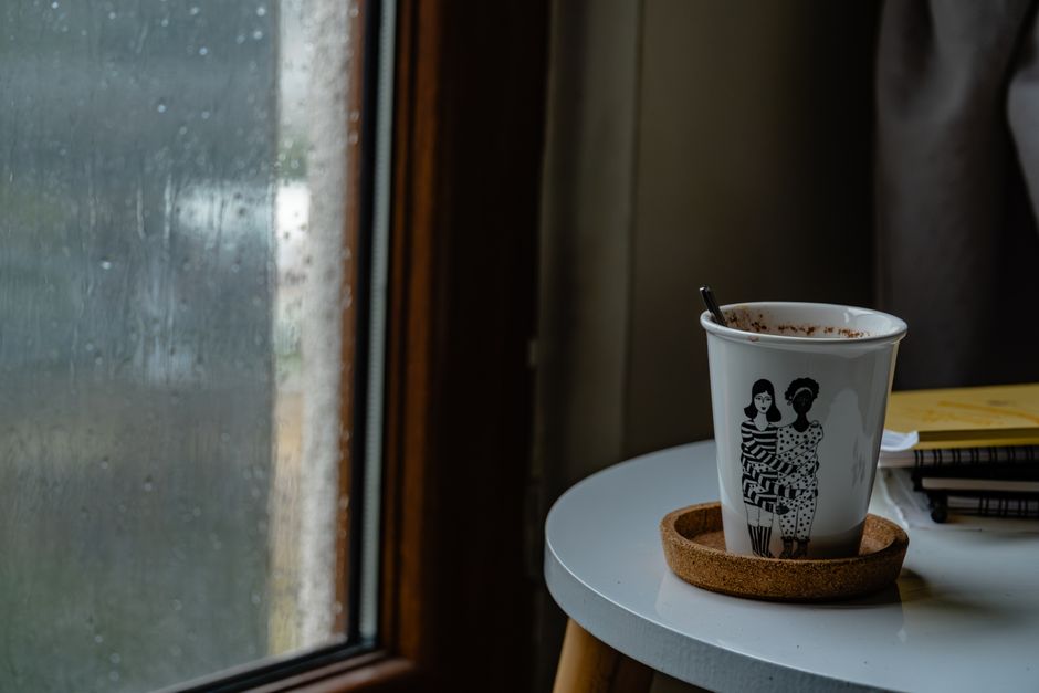 Cup on a small table beside a window
