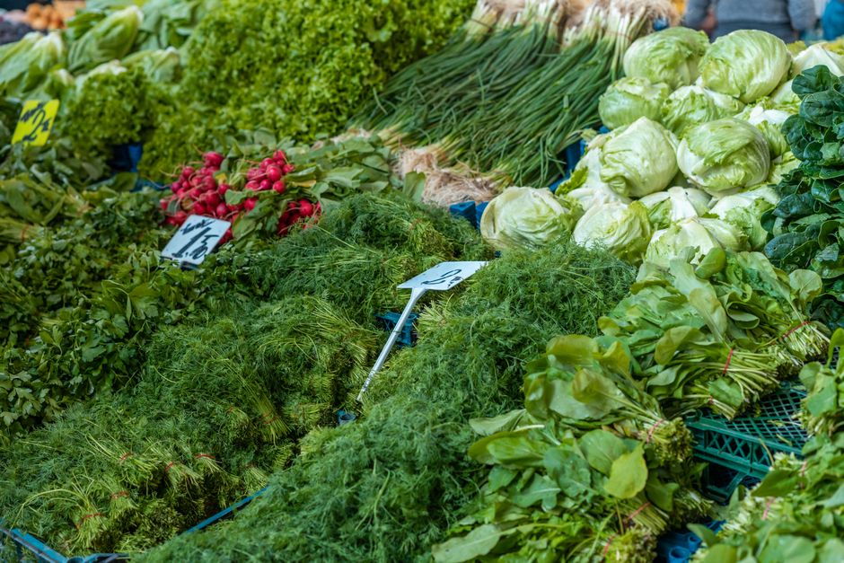 Fresh green vegetables and herbs at a farmers market