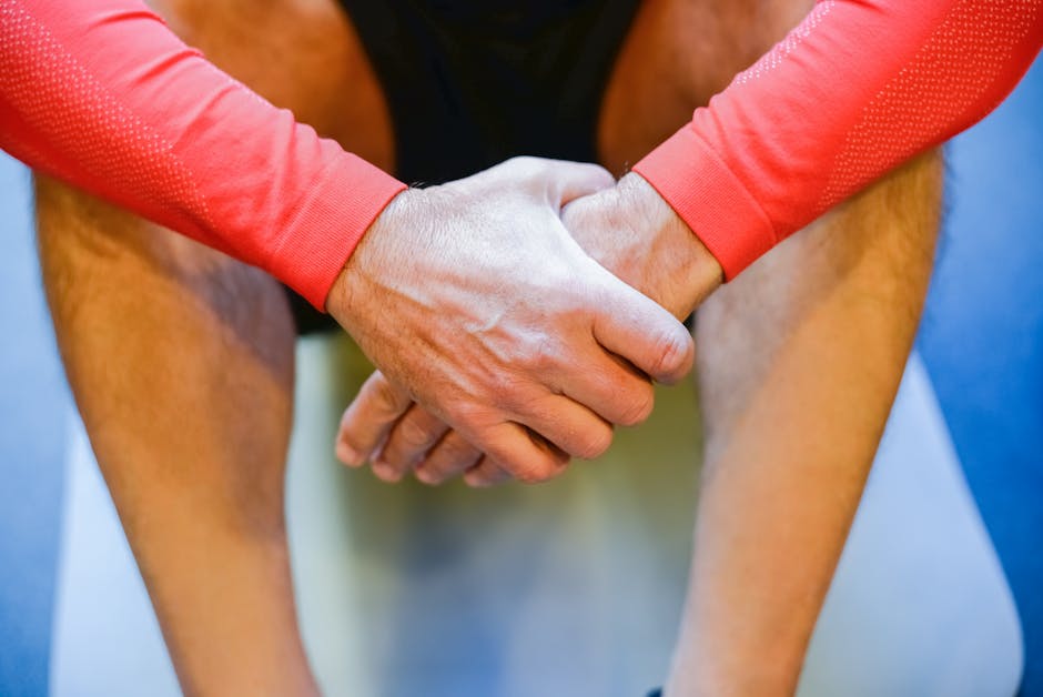 Focused view of a man's hands resting on a yoga mat while wearing sportswear. Perfect for fitness and wellness themes.