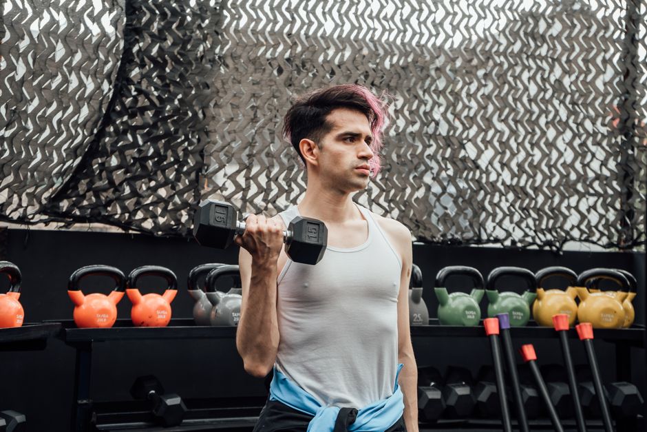 Man doing a dumbbell curl in a gym