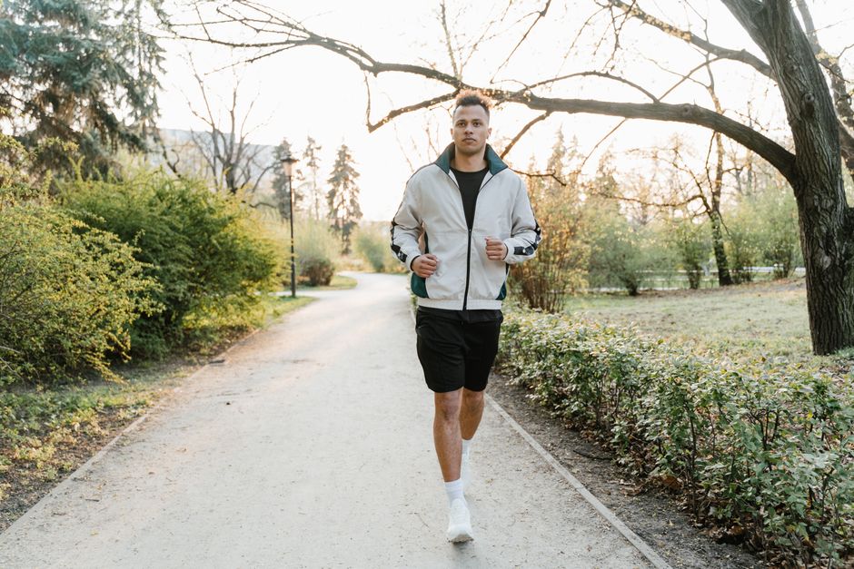 Man running along a tree-lined path
