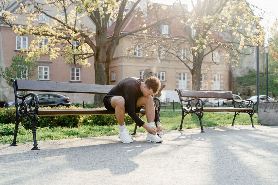 Runner tying shoes on a bench before a run