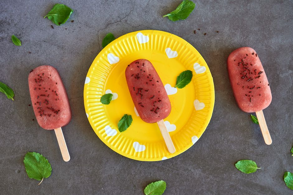 Small fruit popsicles on a yellow plate
