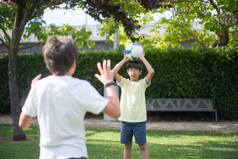 Two children playing with a ball outdoors