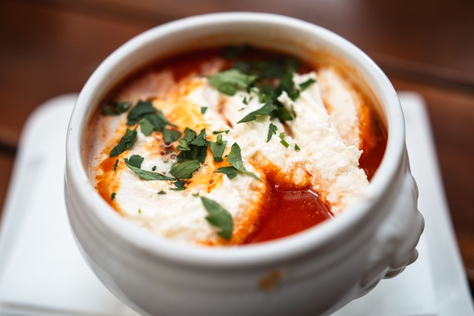 White bowl of soup garnished with herbs