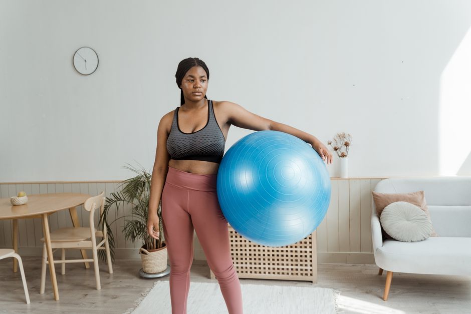 Woman holding an exercise ball while working out at home
