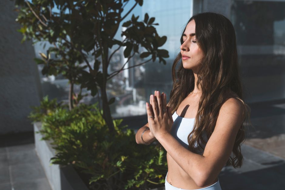 Woman with hands together in a calm outdoor pose